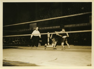 Fighters exchange blows with referee looking on.