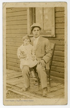 Joe Parisi, a suspected member of the mafia group Blackhand Society, sits with a child on his lap.