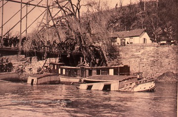 Onlookers survey the damage of flooding on the banks of the Potomac River.