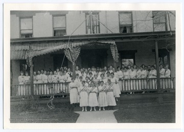 Caption reads: "Flo Lantz as Goddess of Liberty. Carrie Kate Fleming Scrapbook." The Hall refers to the WVU Woman's Hall.