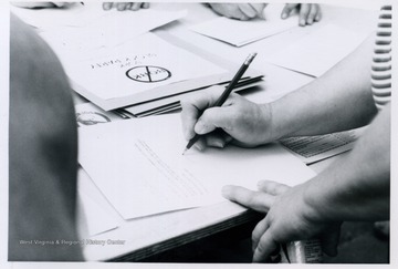 A woman named Judy signing the first petition against nominating Robert Bork to the Supreme Court made at the Block Bork Protest.