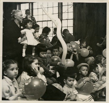 Pearl S. Buck sitting with children at a reunion at her home in Dublin, Pennsylvania.